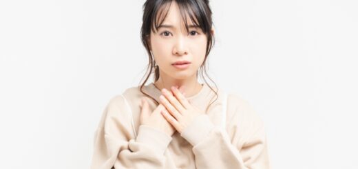 喉に手を当てる女性